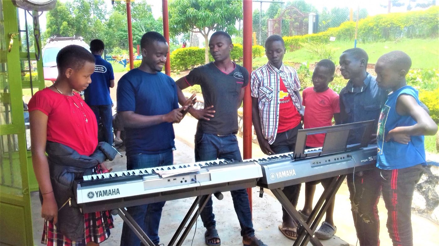 Disan Kato explaining the keyboard to young people