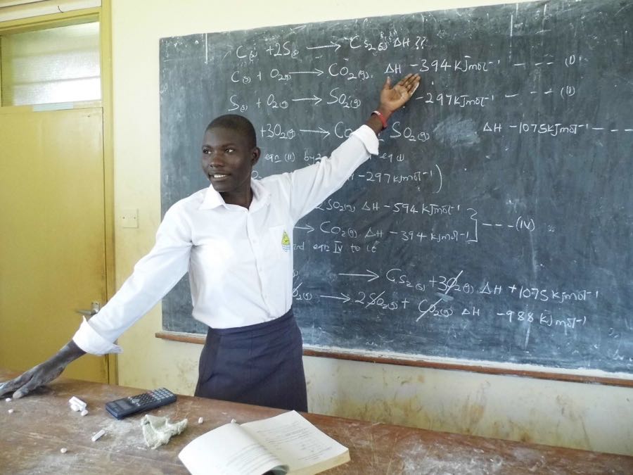 student writing on blackboard